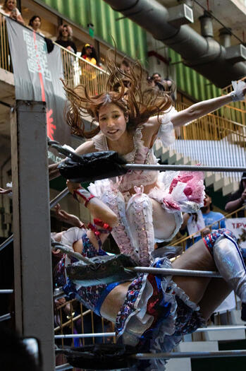 Mizuki stomps her opponent during a tag-team match.